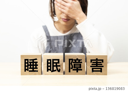「睡眠障害」と書かれたブロックとエプロン姿の女性 136819083