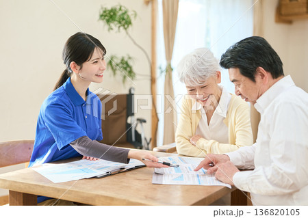 訪問介護でプランの説明をするアジア人介護士 訪問介護でプランの説明をするアジア人介護士 136820105