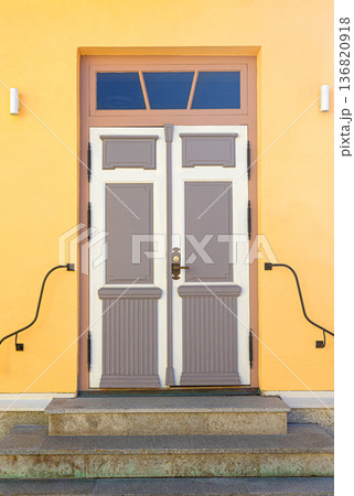 Traditional residential entrance with colorful yellow wall and steps Traditional residential entrance with colorful yellow wall and steps 136820918