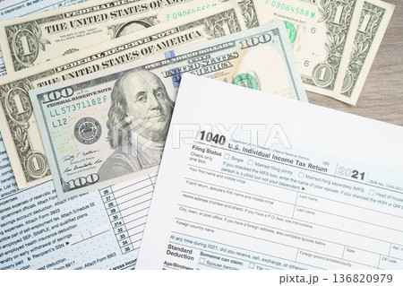 Tax form 1040 U.S. Individual Income Tax Return with dollar banknotes money. 136820979