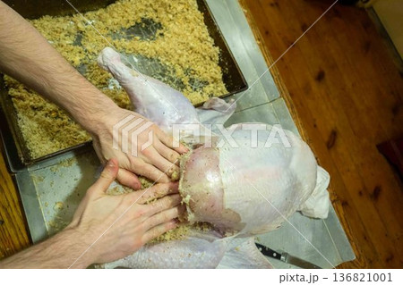 Person stuffing raw turkey Thanksgiving real home kitchen gourmet from scratch food prep 136821001