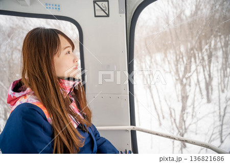 ウィンタースポーツを楽しむために乗り物に乗る若い女性 136821686