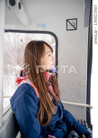 ウィンタースポーツを楽しむために乗り物に乗る若い女性 136821687