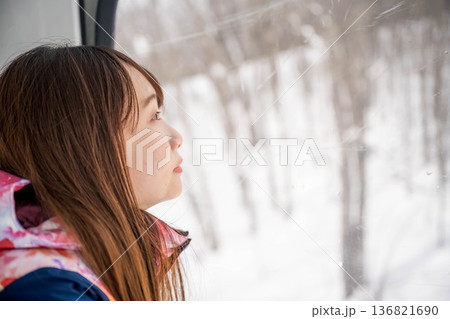 ウィンタースポーツを楽しむために乗り物に乗る若い女性 136821690