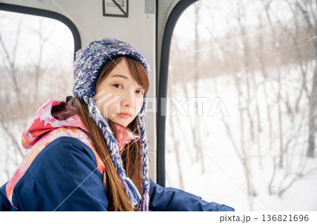 ウィンタースポーツを楽しむために乗り物に乗る若い女性 136821696