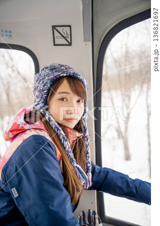 ウィンタースポーツを楽しむために乗り物に乗る若い女性 ウィンタースポーツを楽しむために乗り物に乗る若い女性 136821697