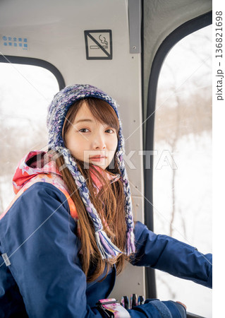 ウィンタースポーツを楽しむために乗り物に乗る若い女性 ウィンタースポーツを楽しむために乗り物に乗る若い女性 136821698