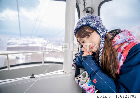ウィンタースポーツを楽しむために乗り物に乗る若い女性 ウィンタースポーツを楽しむために乗り物に乗る若い女性 136821703