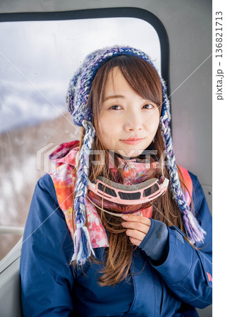 ウィンタースポーツを楽しむために乗り物に乗る若い女性 136821713