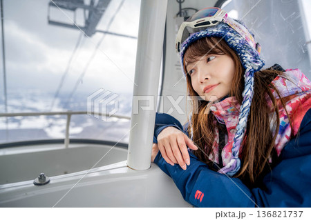 ウィンタースポーツを楽しむために乗り物に乗る若い女性 136821737