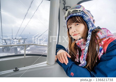 ウィンタースポーツを楽しむために乗り物に乗る若い女性 ウィンタースポーツを楽しむために乗り物に乗る若い女性 136821738