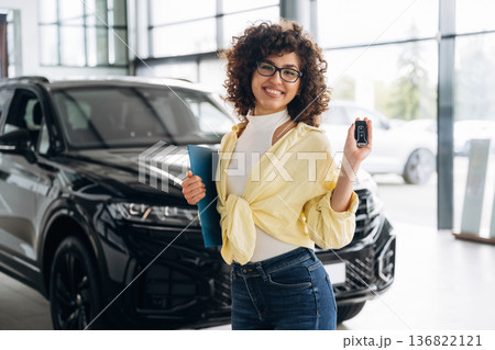 In casual clothes, with keys in hand. Pretty woman is in the car retail shop 136822121