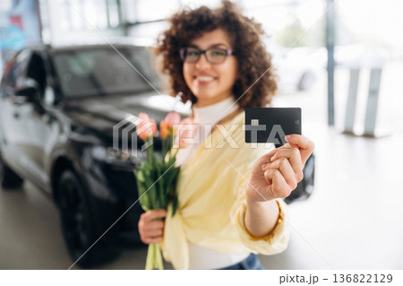 Bought herself a flowers by using credit card. Pretty woman is in the car retail shop 136822129