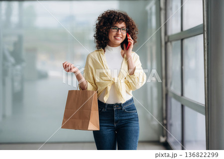 Beautiful woman is standing indoors against blurred wall Beautiful woman is standing indoors against blurred wall 136822299