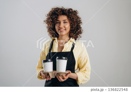 The service, two cups of drinks. Beautiful female waiter is in the studio The service, two cups of drinks. Beautiful female waiter is in the studio 136822548