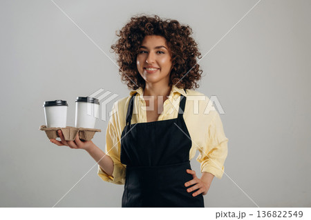 The service, two cups of drinks. Beautiful female waiter is in the studio The service, two cups of drinks. Beautiful female waiter is in the studio 136822549