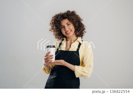 Cup of coffee in hands. Beautiful female waiter is in the studio Cup of coffee in hands. Beautiful female waiter is in the studio 136822554