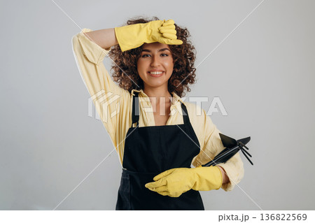 She wipes her forehead, tired of cleaning. Beautiful woman is in the studio She wipes her forehead, tired of cleaning. Beautiful woman is in the studio 136822569