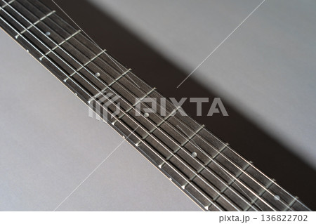 Close-up of a dark wooden guitar fretboard neck 136822702