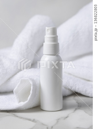 Mockup of white blank spray cosmetic bottle near white bath terry towel for spa hotel use Mockup of white blank spray cosmetic bottle near white bath terry towel for spa hotel use 136822803