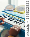 おもちゃピアノを弾く子どもの手元アップ 教育プレゼンやスライドショーに使える音楽イメージ背景素材 136822822
