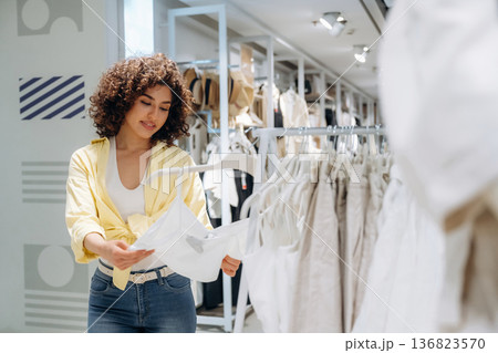 Woman is shopping in the clothing store Woman is shopping in the clothing store 136823570