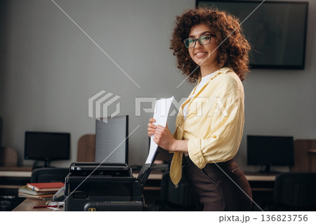 Woman is in the library section with computers Woman is in the library section with computers 136823756