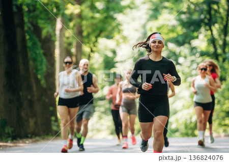 Joggers are on the road. Group of runners are together outdoors Joggers are on the road. Group of runners are together outdoors 136824076