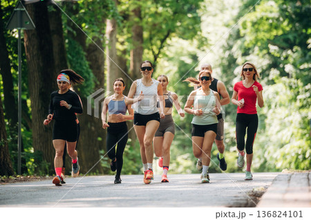 Training and jogging. Group of runners are together outdoors 136824101