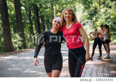 Female friends are standing. Group of runners are together outdoors Female friends are standing. Group of runners are together outdoors 136824345
