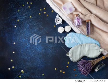 World Sleep Day concept. Bedtime accessories, sleep masks, and classic alarm clock on dark blue wooden background 136824544