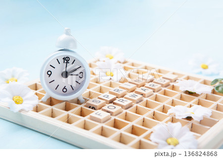 Daylight saving Time, Spring forward, Summer back concept. White Alarm Clock and Spring Daisy Flowers on Blue Background Daylight saving Time, Spring forward, Summer back concept. White Alarm Clock and Spring Daisy Flowers on Blue Background 136824868