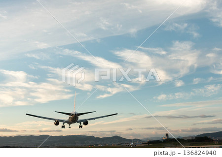 夕暮れの空に着陸する旅客機と穏やかな山並み 夕暮れの空に着陸する旅客機と穏やかな山並み 136824940
