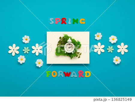 Daylight saving Time, Spring forward, Summer back concept. White Alarm Clock and Spring Daisy Flowers on Blue Background 136825149