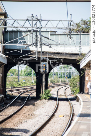 明るい日差しの下のプラットフォームと陸橋のトンネル ロンドン郊外のサウス・オール駅にて 明るい日差しの下のプラットフォームと陸橋のトンネル ロンドン郊外のサウス・オール駅にて 136825774