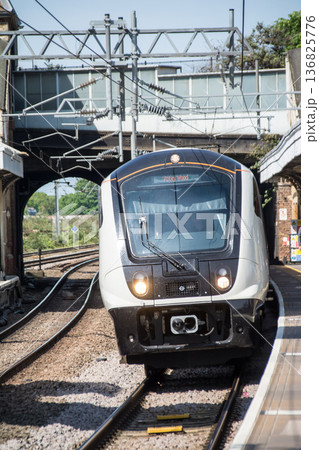 明るい日差しの下のプラットフォームと陸橋のトンネルを通る電車 ロンドン郊外のサウス・オール駅にて 明るい日差しの下のプラットフォームと陸橋のトンネルを通る電車 ロンドン郊外のサウス・オール駅にて 136825776