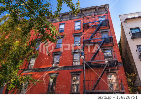 Red brick New York apartment building with classic metal fire escape stairs Red brick New York apartment building with classic metal fire escape stairs 136826751