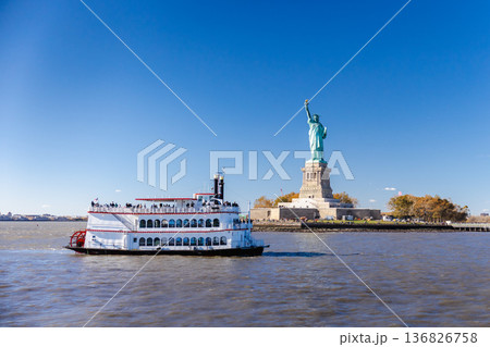 Statue of Liberty and sightseeing ferry boat on Hudson River in New York City Statue of Liberty and sightseeing ferry boat on Hudson River in New York City 136826758