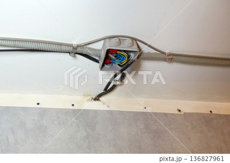 The electrical wires in the protective corrugated cable tube and the junction box are neatly laid on the ceiling 136827961