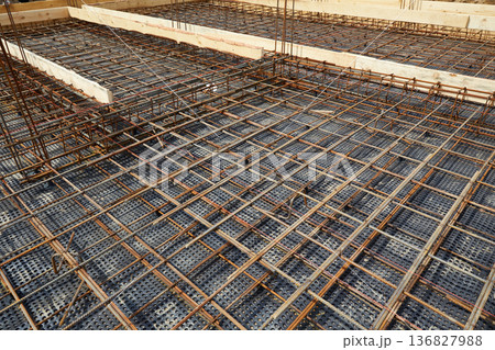 Steel reinforcement is placed in wooden molds and formwork on a construction site  136827988