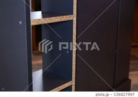 Wooden shelf unit is being assembled in a room with natural light on a weekday in the afternoon Wooden shelf unit is being assembled in a room with natural light on a weekday in the afternoon 136827997