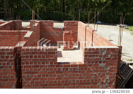 Brick walls rise up at a construction site. House under construction 136828030