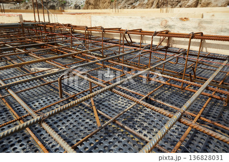 Steel reinforcement is placed in wooden molds and formwork on a construction site  136828031