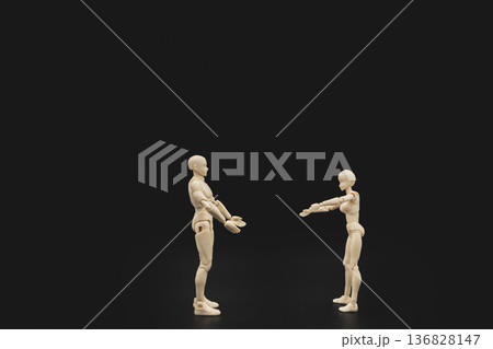 Two plastic mannequins try to hug each other on black background, conceptual art of human connection and intimacy. Two plastic mannequins try to hug each other on black background, conceptual art of human connection and intimacy. 136828147