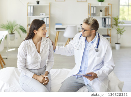 Doctor Or Nurse Consulting Patient During Hospital Visit Providing Assistance 136828331