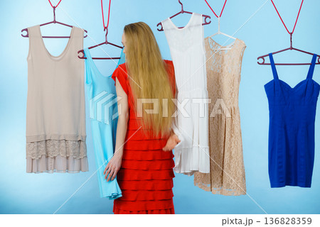 Woman choosing clothes in shop Woman choosing clothes in shop 136828359