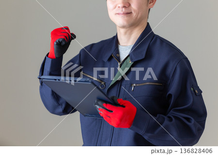 バインダーを持ってガッツポーズをする作業服のミドル男性ビジネスマン 136828406
