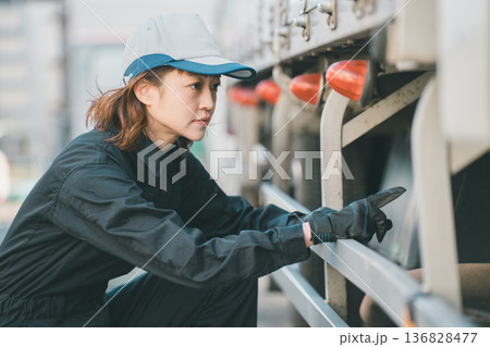 エアタンクを点検する女性トラック整備士 エアタンクを点検する女性トラック整備士 136828477