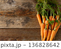 新鮮な葉付きにんじん(木目背景) 136828642