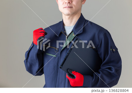 バインダーを持ってガッツポーズをする作業服のミドル男性ビジネスマン 136828804